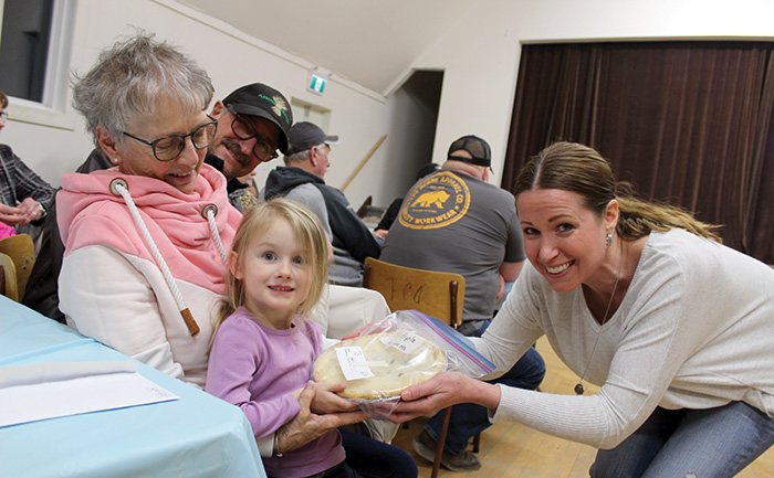 Shown here is Maren Stewart of Rocanville, in her grandmother Beryl Stewart’s arms, after she bid for and won a pie in the children’s auction held at the Fleming Community Hall.<br />
e